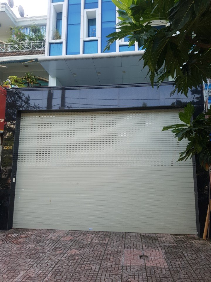 Cửa cuốn tôn màu kem mặt tiền nhà phố hiện đại nhìn từ ngoài vỉa hè