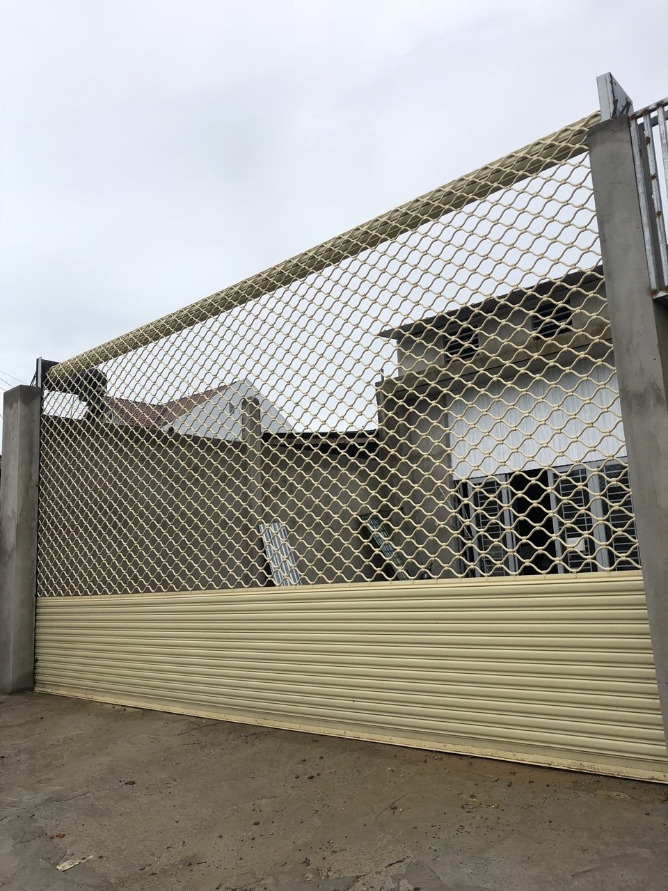 Cửa cuốn khe thoáng màu kem lắp đặt cho mặt tiền nhà xưởng hoặc gara rộng