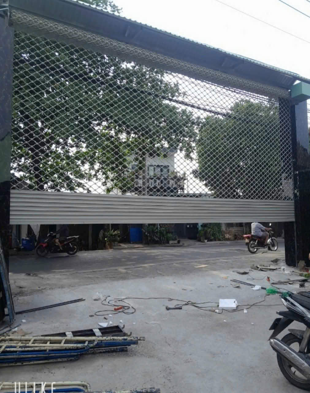Cửa cuốn lưới mắt võng bằng sắt đang thi công lắp đặt tại mặt tiền nhà phố