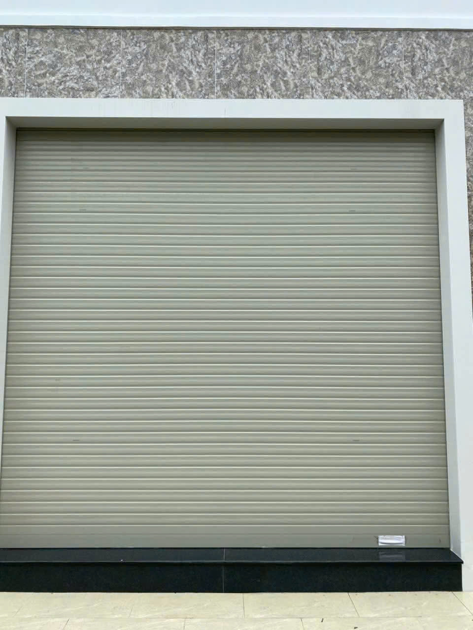 Cửa cuốn nhôm màu xám lắp đặt cho mặt tiền nhà phố hiện đại