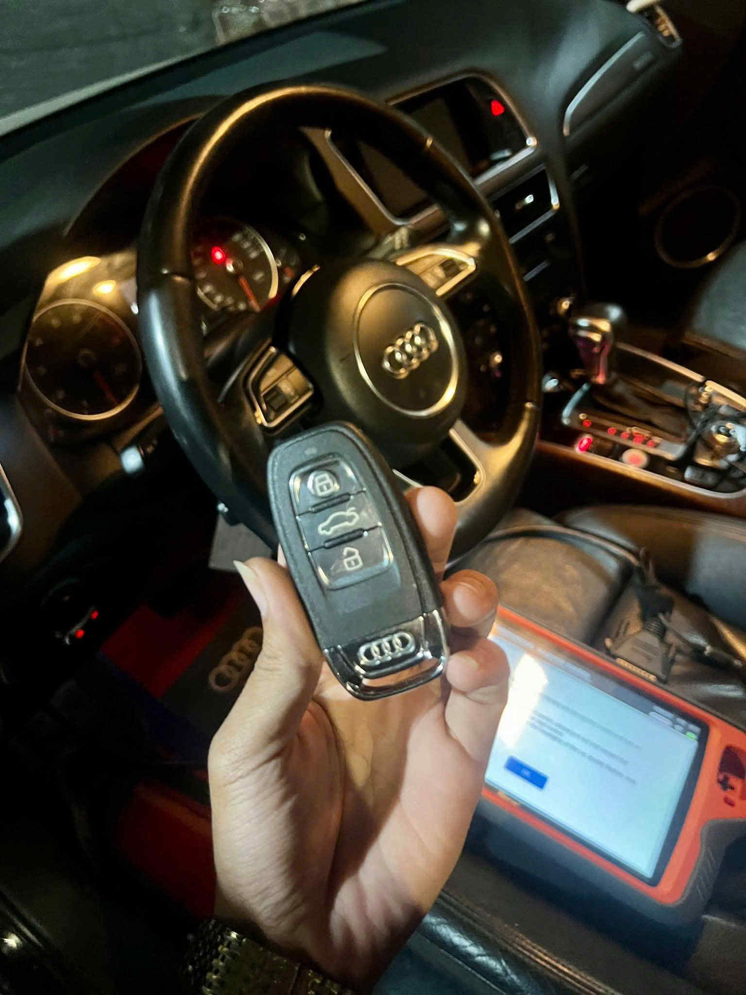 Chìa khóa thông minh ô tô Audi cầm trên tay trong khoang lái xe Audi hiện đại