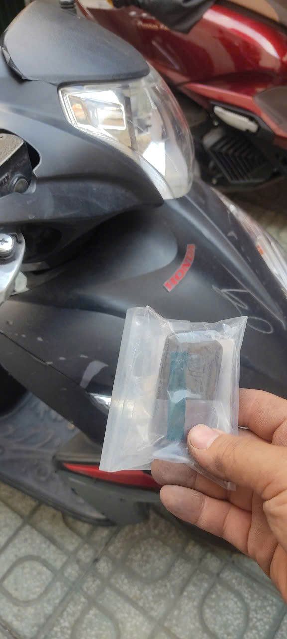 Miếng cao su phụ tùng xe máy Honda mới trong túi nilon được cầm trước đầu xe scooter