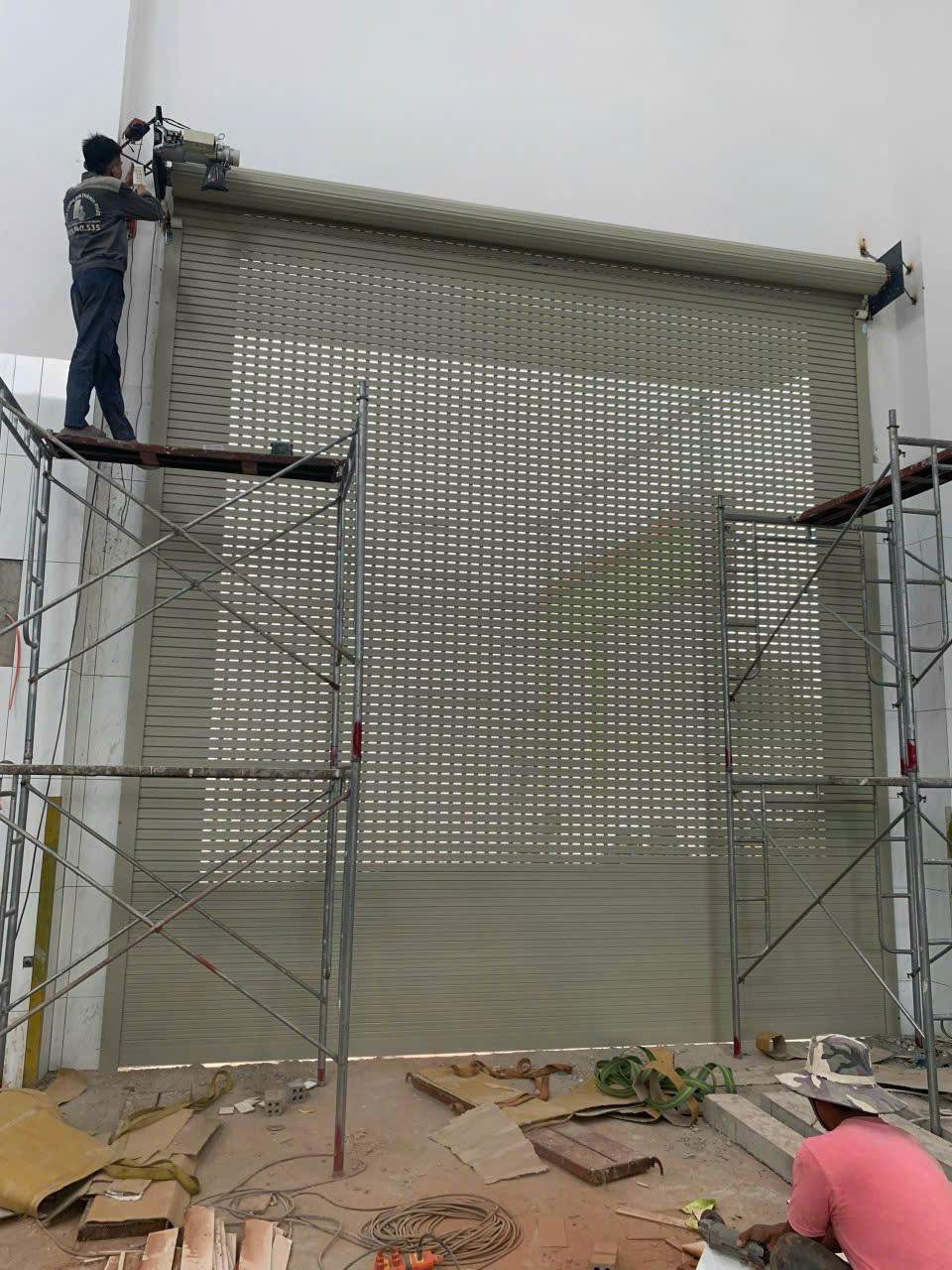 Hình ảnh bảo trì và bảo dưỡng cửa cuốn định kỳ tại Quận 4 giúp hạn chế kẹt cửa, đứt lá và tăng tuổi thọ cửa cuốn.