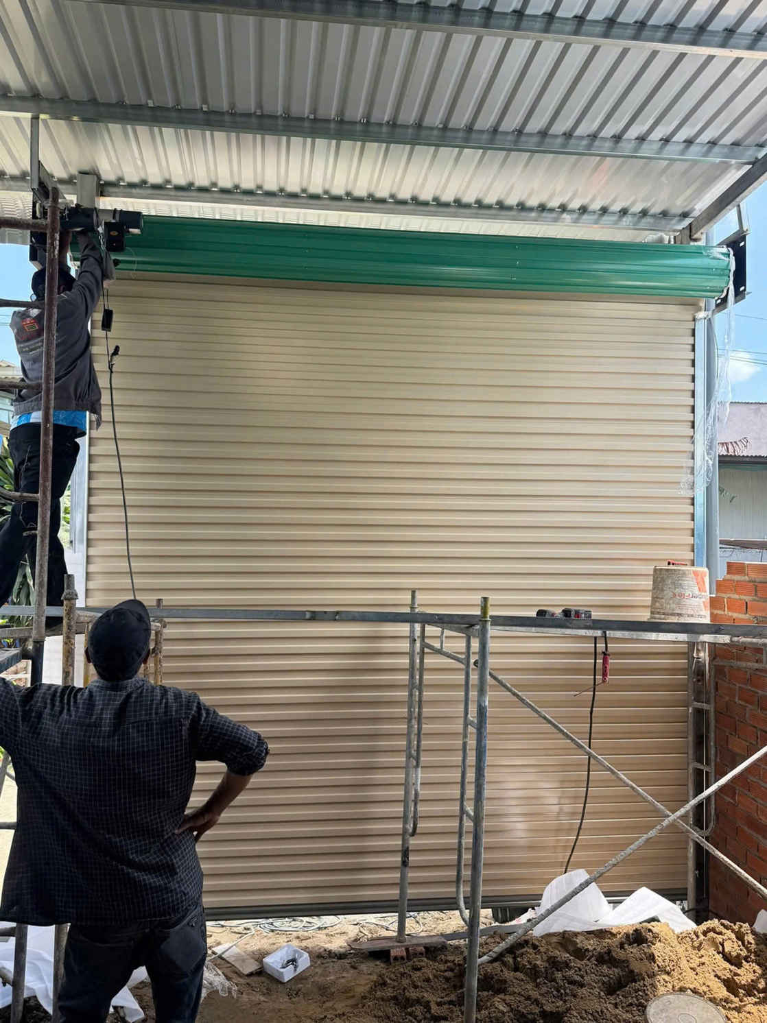 Thi công lắp đặt cửa cuốn tôn màu kem cho nhà xưởng dưới mái tôn rib