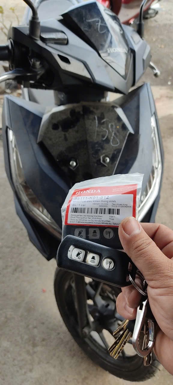 Chìa khóa thông minh Honda và bao bì phụ tùng chính hãng trước đầu xe máy Honda màu đen