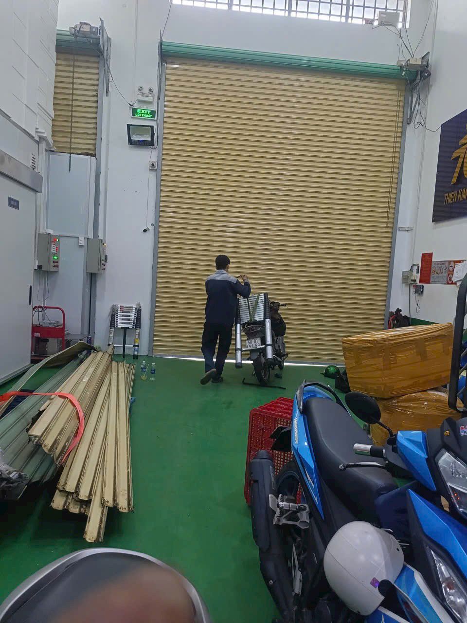 Kỹ thuật viên FIX365 đang sửa cửa cuốn tại nhà khách hàng ở Quận 5, xử lý nhanh tình trạng cửa cuốn bị kẹt và không lên xuống.