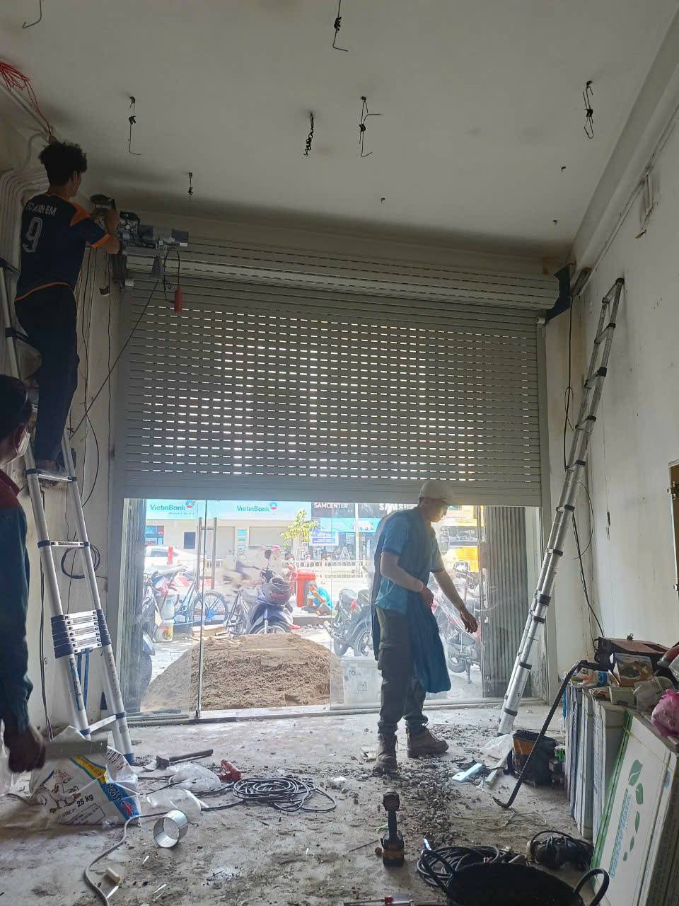 Kỹ thuật viên FIX365 đang kiểm tra và sửa chữa cửa cuốn tại nhà khách hàng ở Quận 8, xử lý nhanh lỗi cửa cuốn bị kẹt.