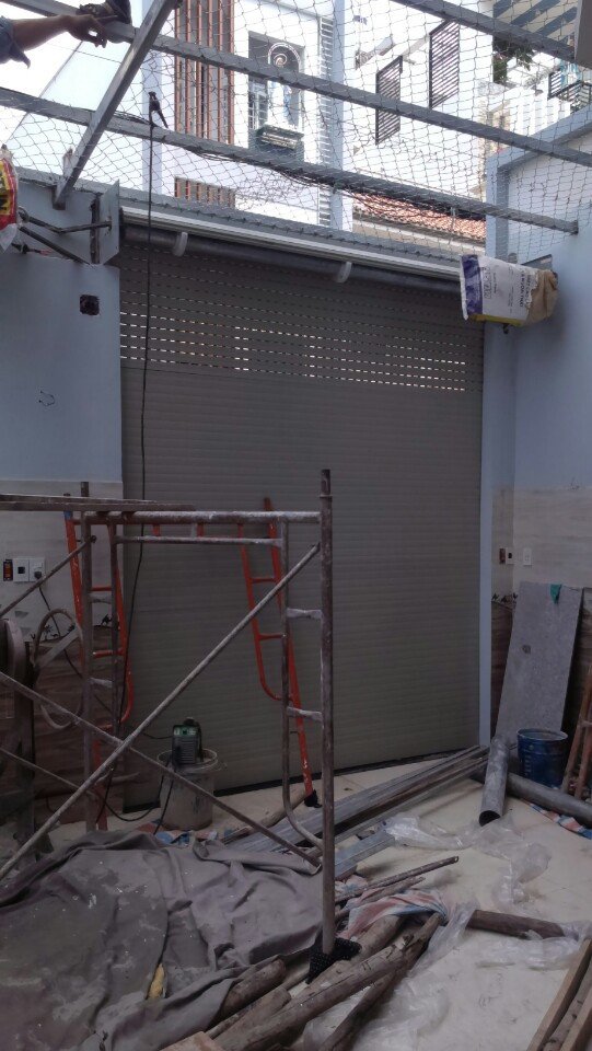 Hình ảnh thợ sửa cửa cuốn Bến Cát căn chỉnh cửa bị lệch, giúp cửa đóng mở trơn tru và đảm bảo an toàn sử dụng.