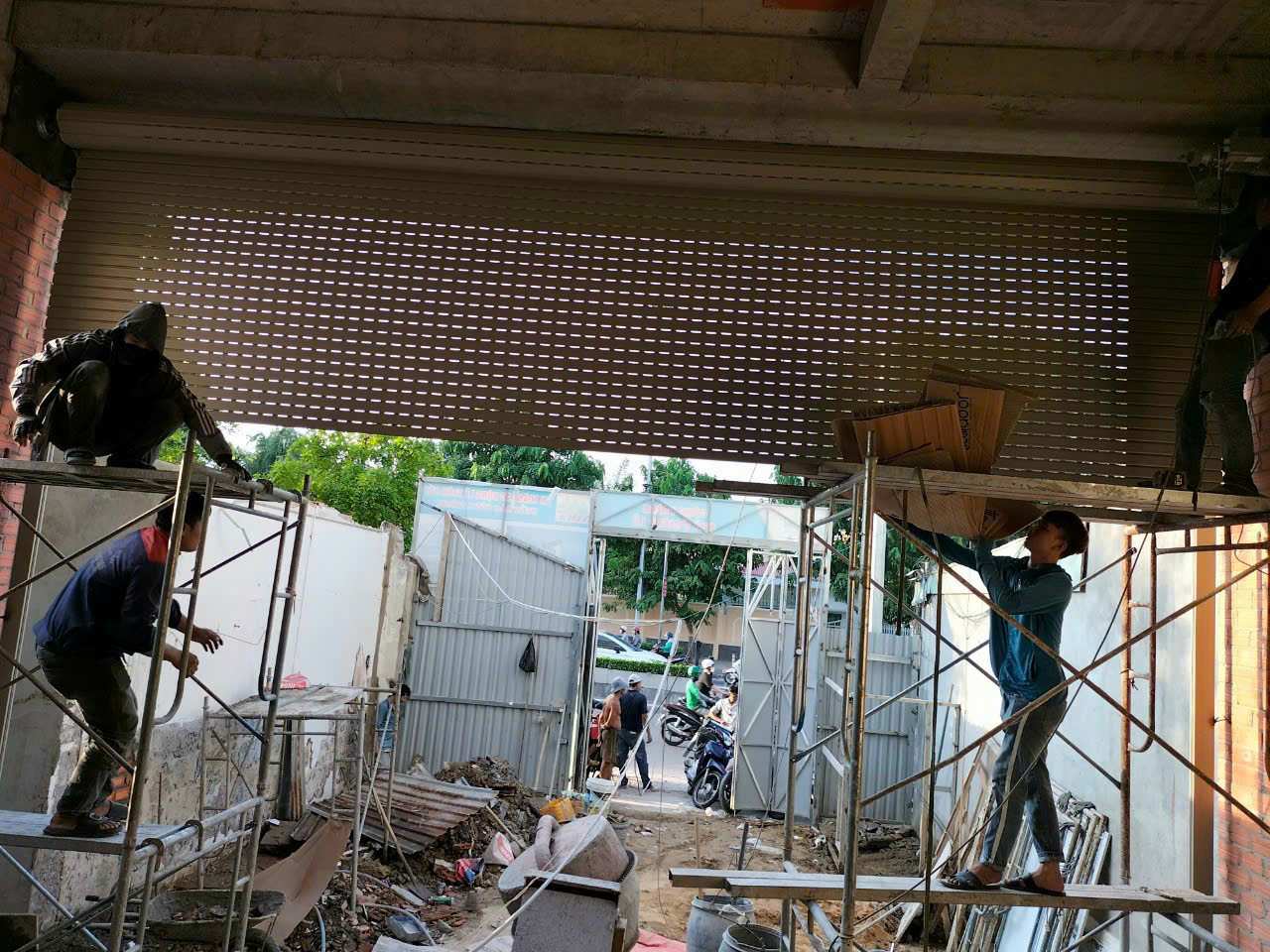 Công nhân sửa cửa cuốn khe thoáng tại công trình xây dựng quận 10