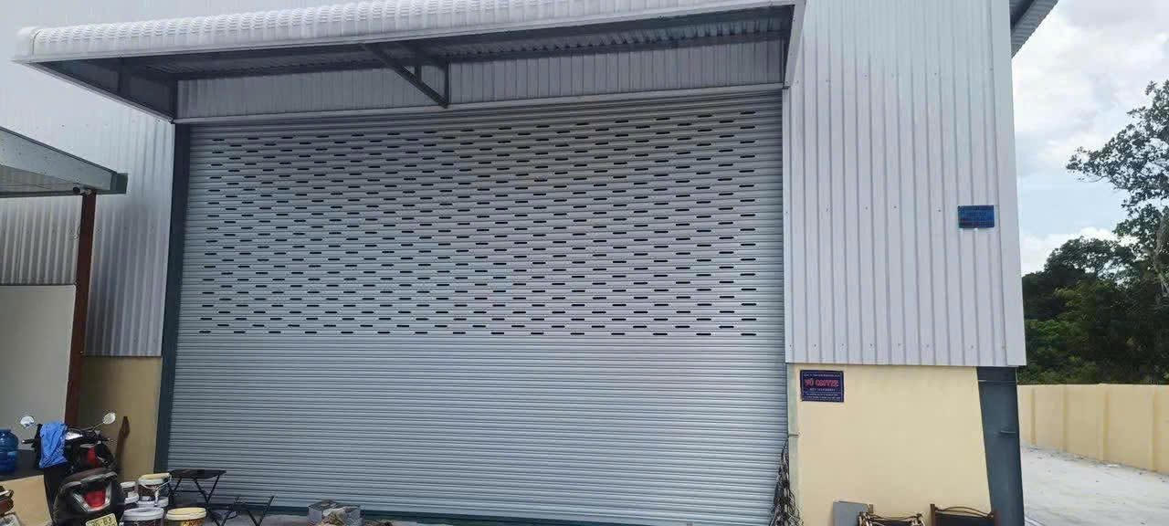 Cửa cuốn tôn màu xám lắp đặt cho mặt tiền nhà xưởng công nghiệp