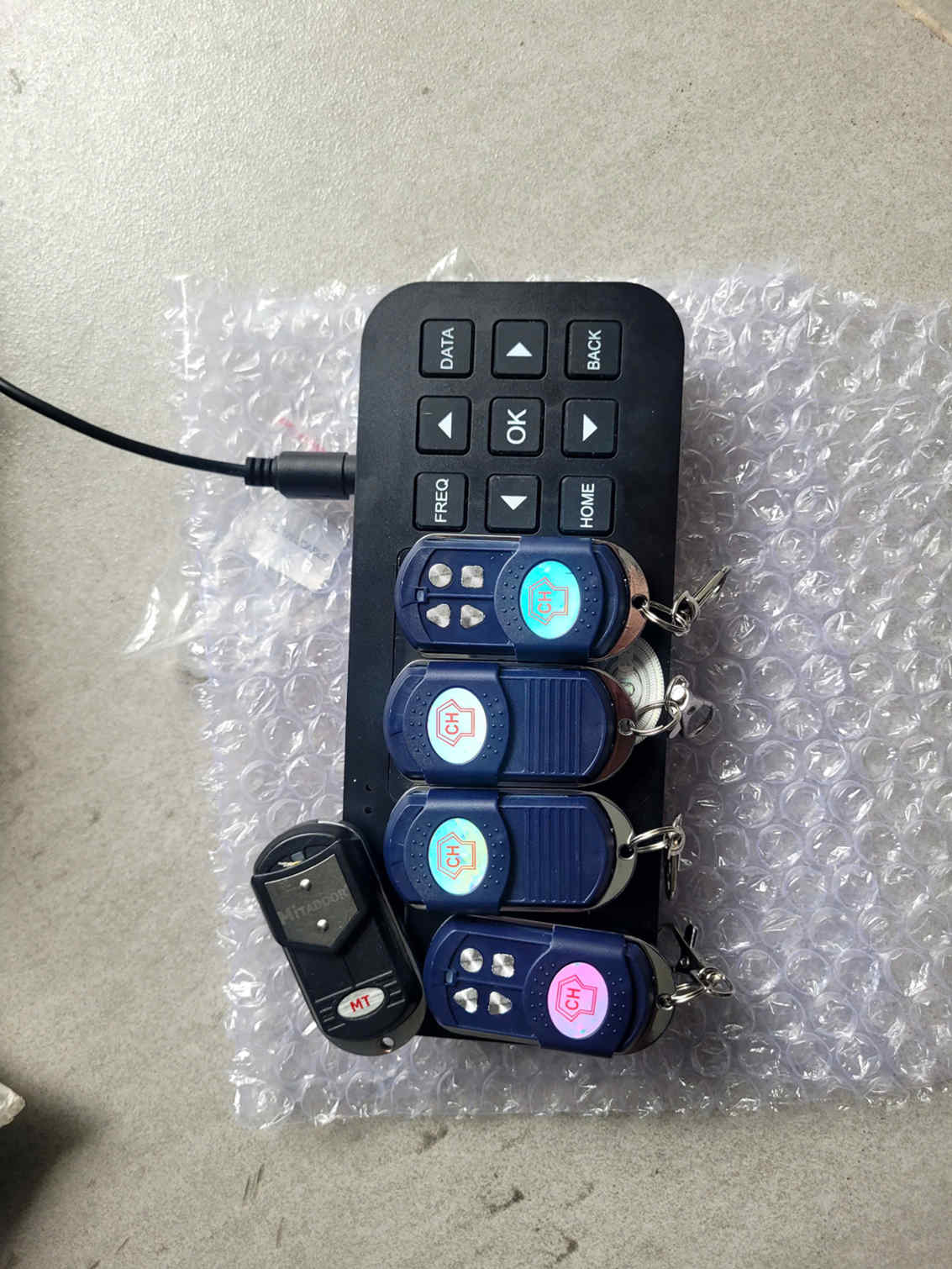 Bộ điều khiển từ xa cửa cuốn CH kèm thiết bị sao chép tần số có dây trên nền xốp hơi